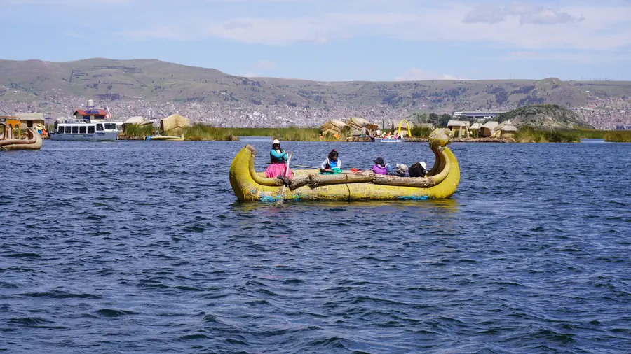 Reed boat sailing past the floating islands of the Uros